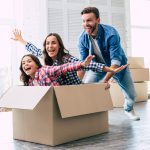 Famille heureuse dans carton déménagement