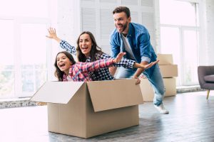Famille heureuse dans carton déménagement