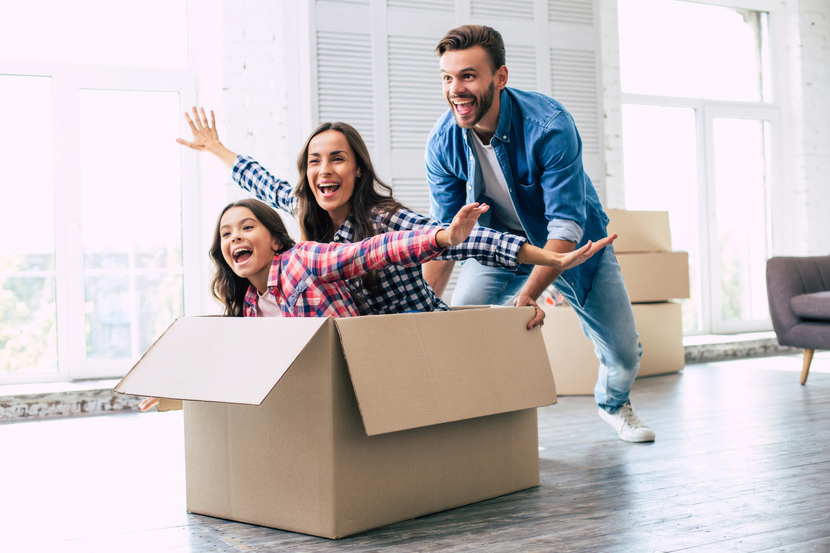 Famille heureuse dans carton déménagement