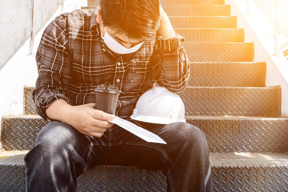 Homme apprenant chomage partiel escalier