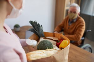 Fille apportant un sac de course à son père âgé handicapé