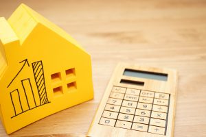 Maison jaune avec courbe augmentation calculatrice en bois