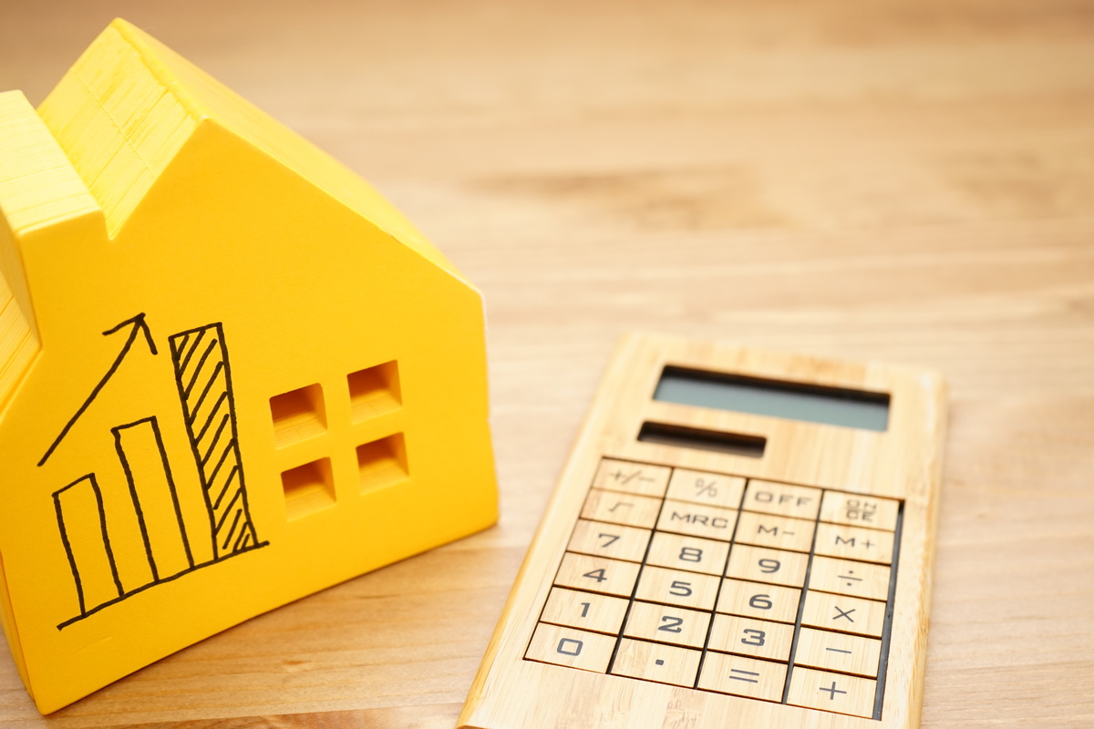 Maison jaune avec courbe augmentation calculatrice en bois