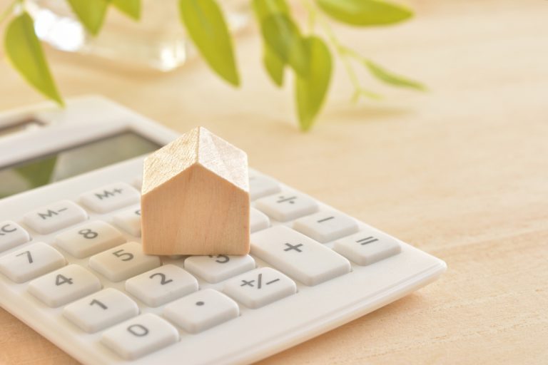 maison sur calculette blanche fond bambous