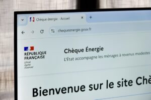 Gros plan sur l'écran d'un ordinateur affichant la page d'accueil du site officiel chequeenergie.gouv.fr, avec la mention "Chèque Énergie - L'État accompagne les ménages à revenus modestes" et l'URL clairement visible.