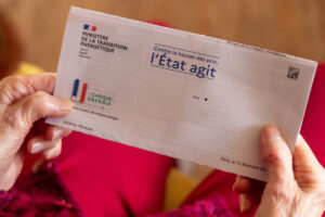 Mains tenant l'enveloppe officielle du chèque énergie envoyée par le ministère de la Transition énergétique.