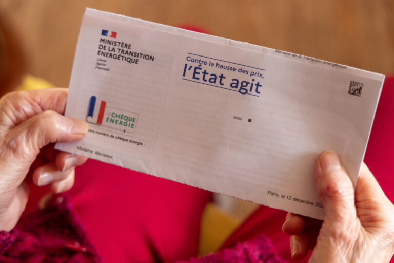 Mains tenant l'enveloppe officielle du chèque énergie envoyée par le ministère de la Transition énergétique.
