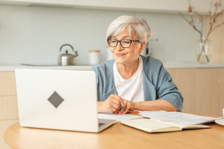 Femme senior lunettes ordinateur portable réclamation en ligne CAF formulaire saisine médiateur