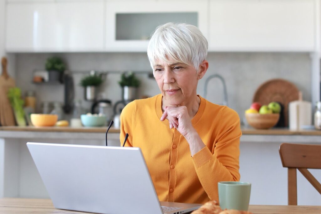 Femme retraitée en retraite progressive analysant son budget sur ordinateur