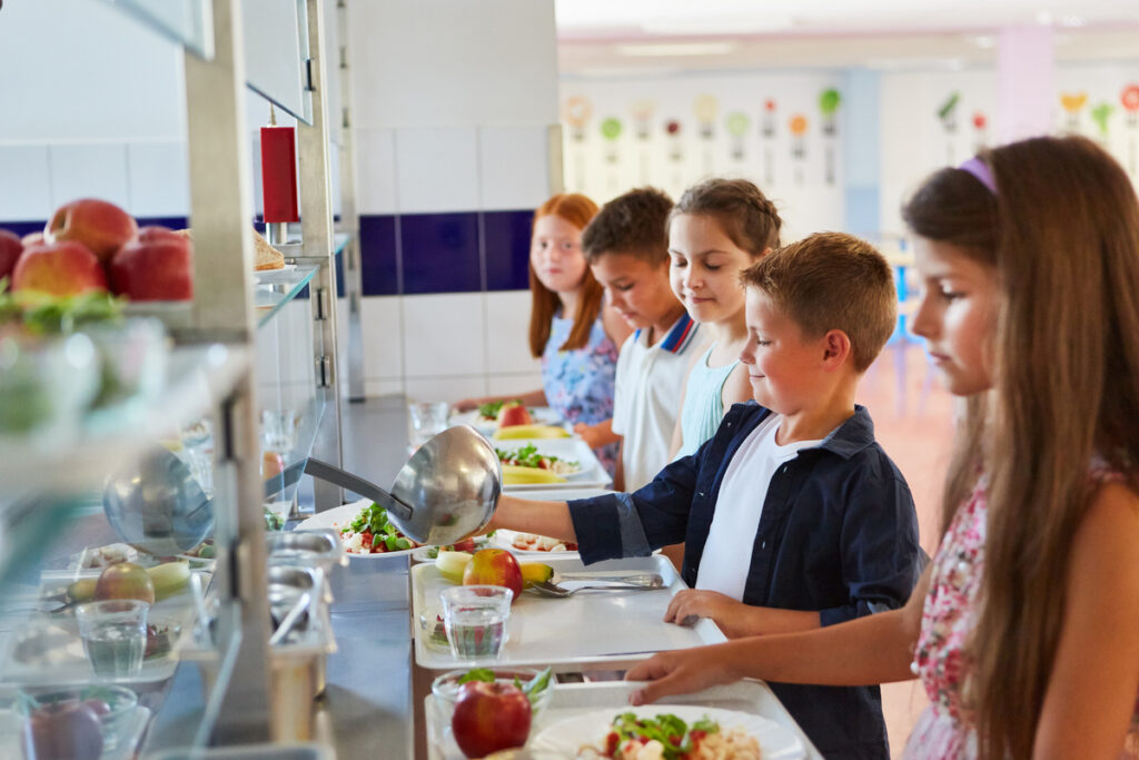 Des enfants font la queue au self de la cantine de leur école, dont le prix dépend directement du calcul du quotient familial.
