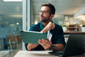 Entrepreneur indépendant utilisant une tablette pour déclarer ses revenus auto-entrepreneur CAF