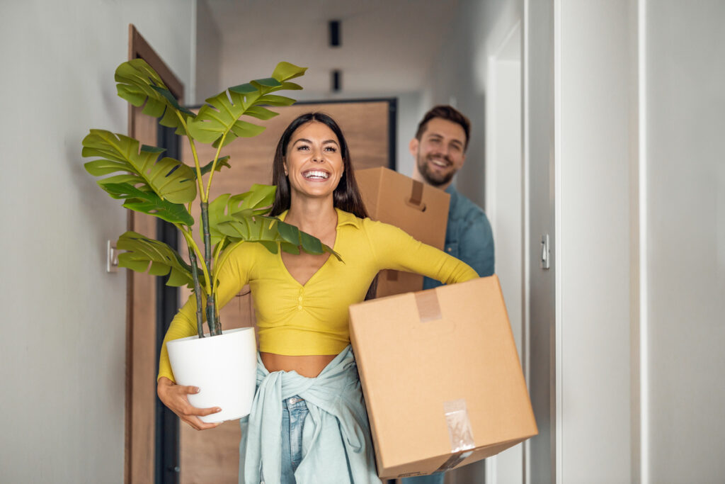 Couple portant des cartons lors d'un déménagement suite à une mutation en logement social