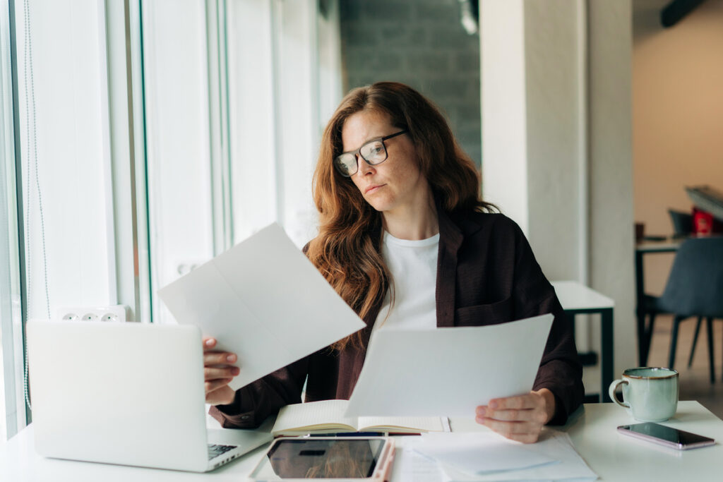 Femme préparant ses documents administratifs pour un rendez-vous avec un travailleur social CAF