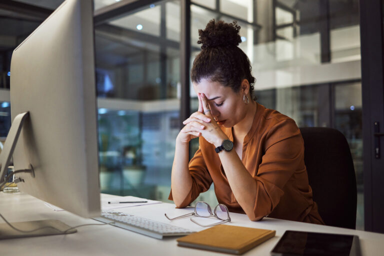Femme stressée devant son ordinateur lors de la gestion de ses démarches liées à la suppression Prime d'activité.