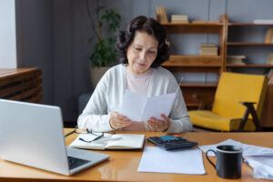 Femme vérifiant son salaire net et ses documents administratifs pour la CAF