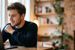 Jeune étudiant connecté sur son ordinateur portable pour effectuer ses démarches liées à la CSS étudiant.
