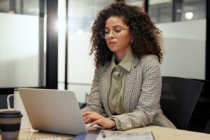 Jeune femme vérifiant ses droits sur un ordinateur portable pour le cumul de la prime d'activité