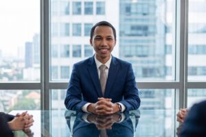 Un jeune homme souriant en entretien professionnel, illustrant le succès d'un parcours dans le cadre du Contrat d’Engagement Jeune.