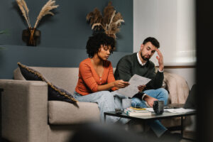 Un couple analyse des documents financiers, illustrant l'impact de la bourse lycée sur les prestations CAF et la gestion du budget familial.
