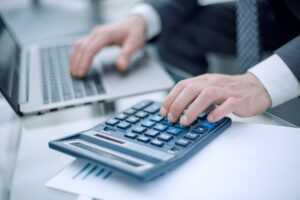 Un professionnel effectue des calculs de paie sur ordinateur pour déclarer ses IJSS à la CAF