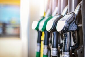 Pistolets de distribution de carburant en station-service pour illustrer la demande d'aide carburant 2026