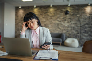 Femme inquiète devant son ordinateur gérant un trop-perçu CAF causé par une erreur DSN
