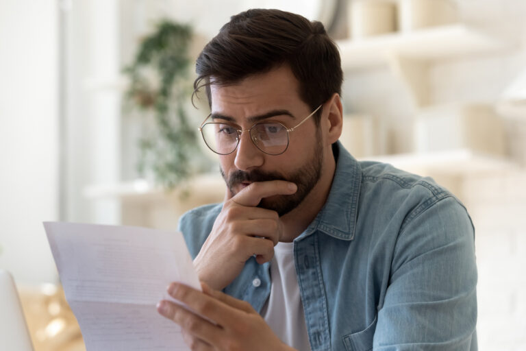 Homme inquiet lisant un courrier officiel annonçant un RSA suspendu